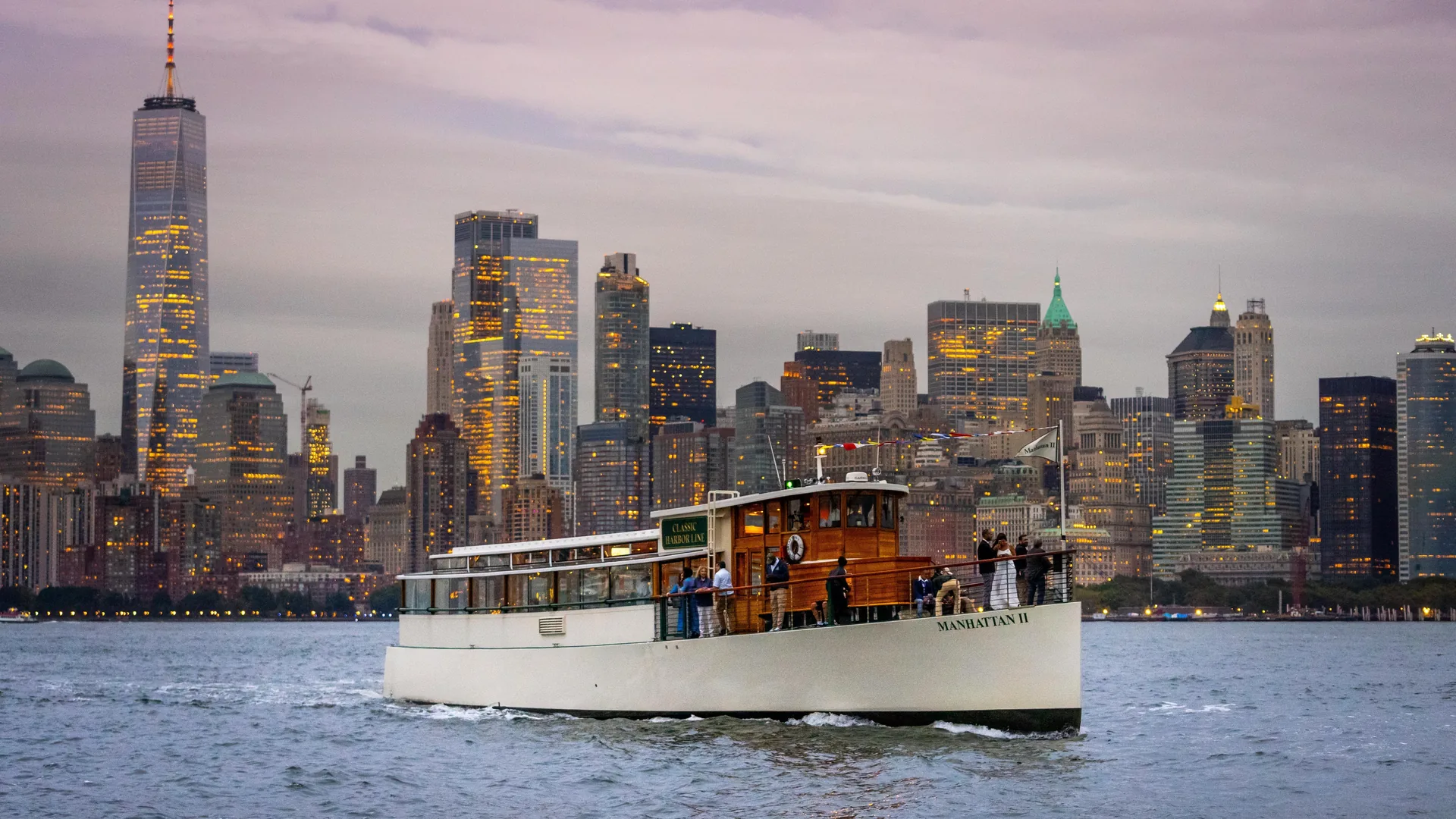 A Classic Harbor Line 1920s-style yacht passing the lower-Manhattan skyline, from the sunset yacht listing