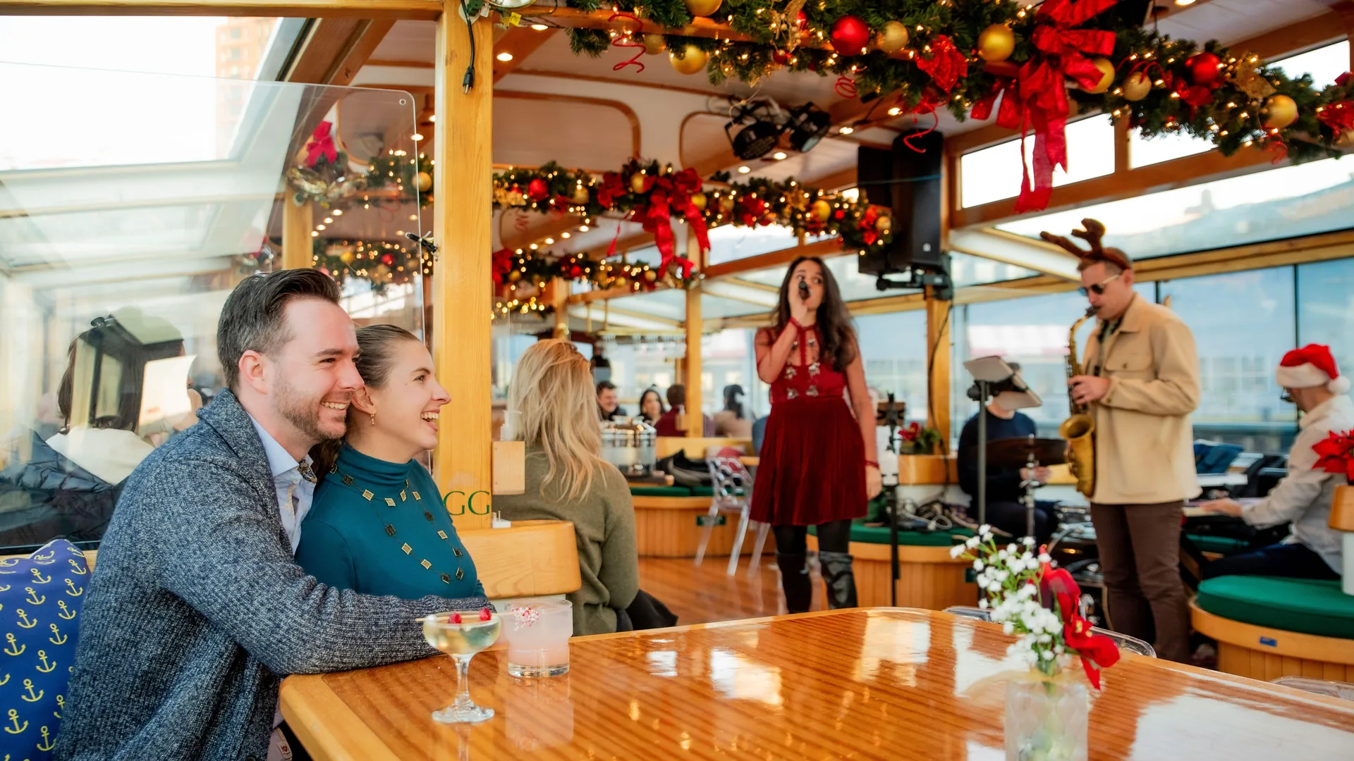 Guests in the decorated salon of a Classic Harbor Line yacht in December, from the holiday cruise listing